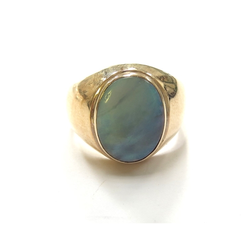 6047 - A gold signet ring with an oval opal in rub over setting, stamped 14k. Size U, 6g