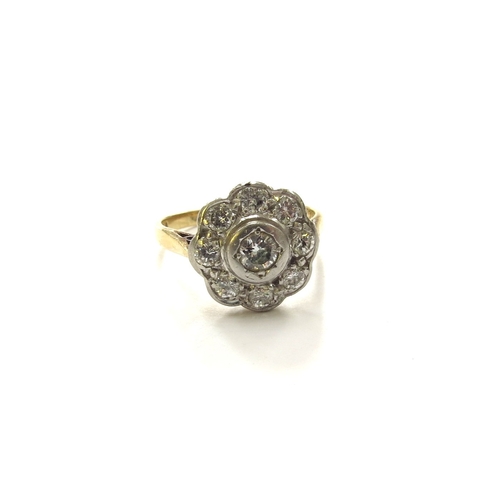 6062 - An 18ct gold/palladium platinum set diamond daisy ring in rubover setting. Size K/L, 3.2g