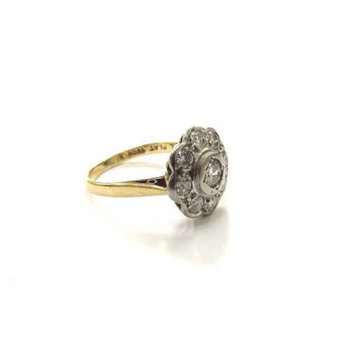 6062 - An 18ct gold/palladium platinum set diamond daisy ring in rubover setting. Size K/L, 3.2g