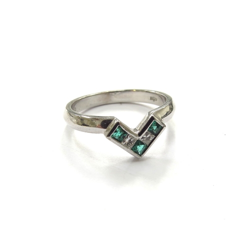 6159 - An 18ct white gold ring with centre V set with three square cut emeralds and two square cut diamonds... 