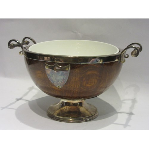 1018 - An oak staved bowl with plated band handles, shields and feet, and a ceramic liner. 24.5x32x19cm