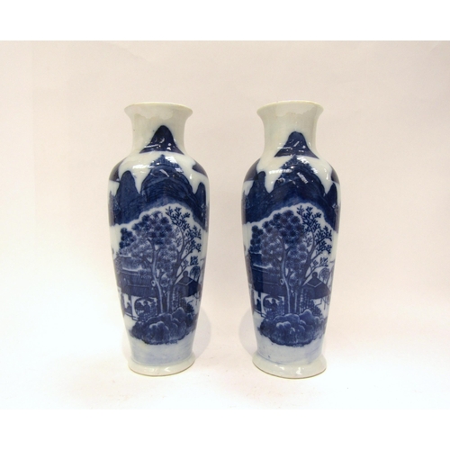 1187 - A near pair of Japanese blue and white ceramic vases with dwellings and rocky outcrop decoration, wi... 