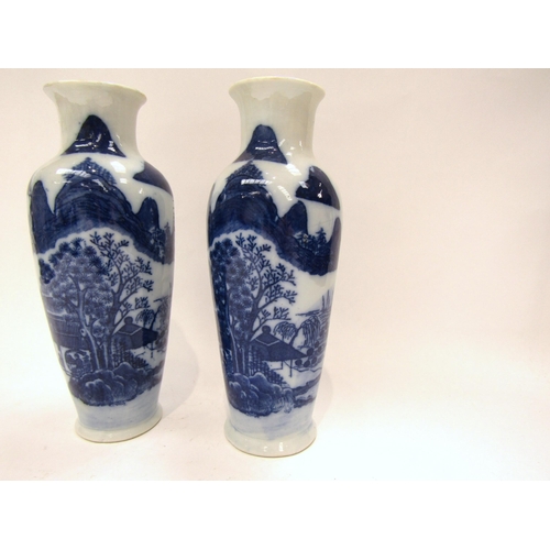 1187 - A near pair of Japanese blue and white ceramic vases with dwellings and rocky outcrop decoration, wi... 