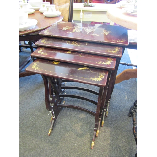 1194 - A Chinese lacquered nest of four tables with gilt scenes of birds among foliage, largest 69cm tall x... 