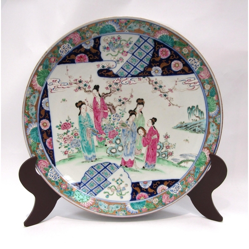 1204 - A Japanese porcelain charger with enamel decoration, the floral and gold border surrounds an image o... 