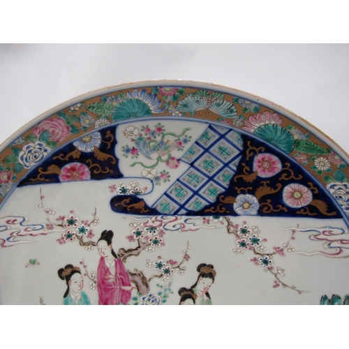 1204 - A Japanese porcelain charger with enamel decoration, the floral and gold border surrounds an image o... 