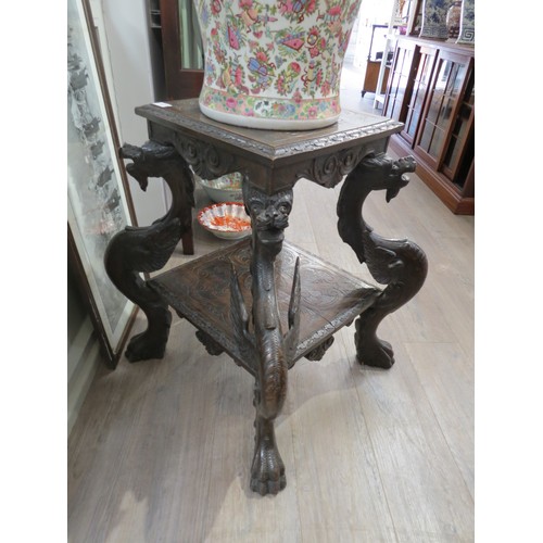 1214 - A late 19th Century mahogany two tier table with winged dragon supports, some repairs, 71cm tall