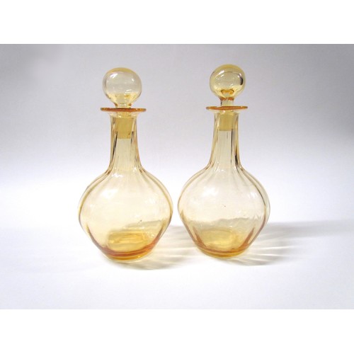 1540 - A pair of circa 1930's/40's amber glass decanters and stoppers, wrythen detail, polished pontils.  2... 