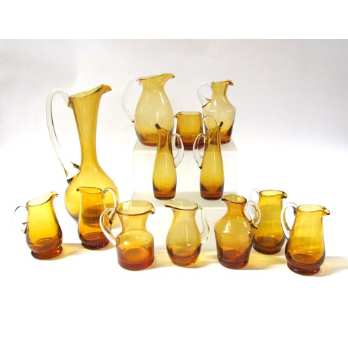 1546 - A collection of fifteen Amber glass jugs including Whitefriars, Krosno, etc.  Tallest 28cm