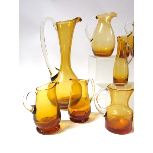 1546 - A collection of fifteen Amber glass jugs including Whitefriars, Krosno, etc.  Tallest 28cm