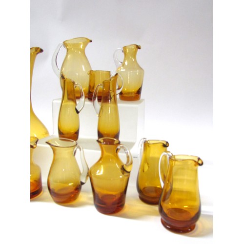 1546 - A collection of fifteen Amber glass jugs including Whitefriars, Krosno, etc.  Tallest 28cm