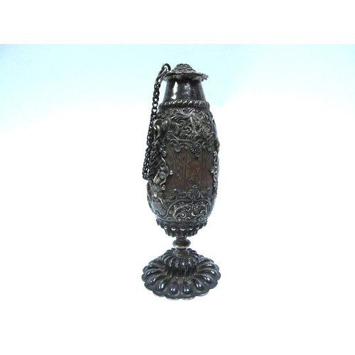 6327 - A 19th Century continental heavily carved nut bottle, encased in an ornate white metal frame. 18cm t... 