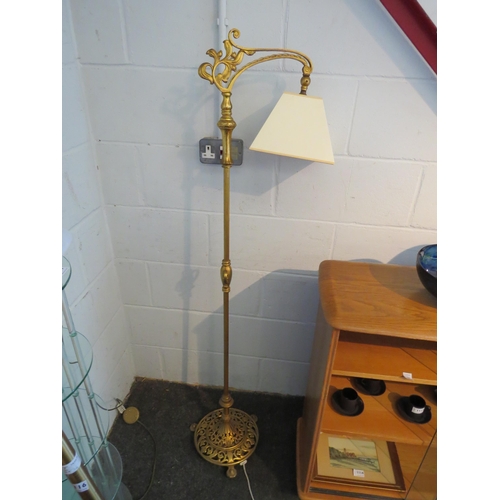 1115 - A brass effect standard lamp in an earlier style, cream shade