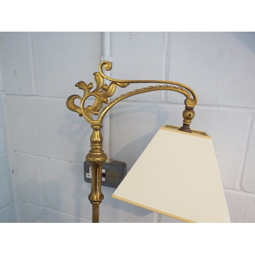 1115 - A brass effect standard lamp in an earlier style, cream shade