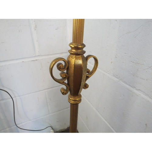 1115 - A brass effect standard lamp in an earlier style, cream shade