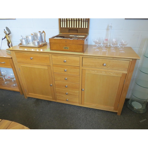 1123 - A natural oak sideboard with eight drawers and two single door cupboards, 93cm tall x 169cm wide x 4... 