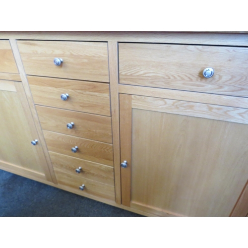 1123 - A natural oak sideboard with eight drawers and two single door cupboards, 93cm tall x 169cm wide x 4... 