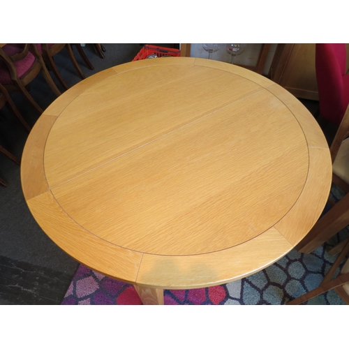 1134 - A natural oak extending circular dining table with internal fold-out leaf