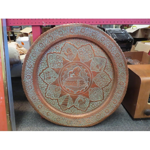 1159 - An Eastern copper charger with floral design, frilled edge, 60cm diameter