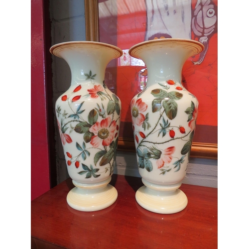 1188 - A pair of glass vases over painted with roses, 32cm tall