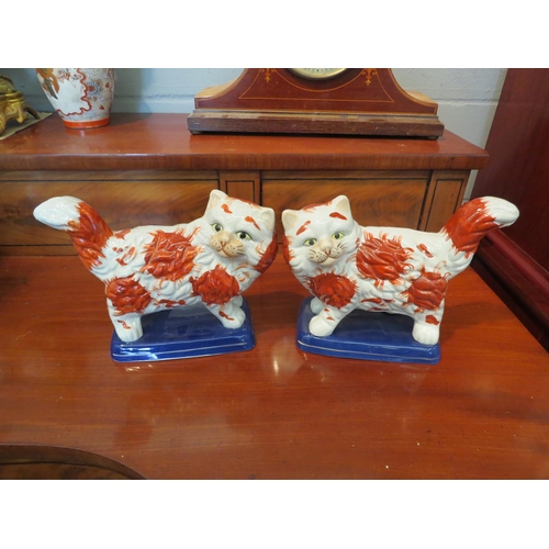 1232 - A pair of reproduction Staffordshire cats, 24.5cm long