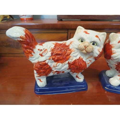 1232 - A pair of reproduction Staffordshire cats, 24.5cm long