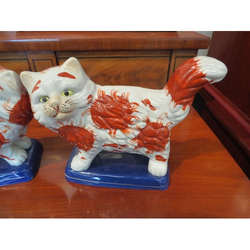 1232 - A pair of reproduction Staffordshire cats, 24.5cm long