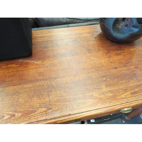 1269 - A Victorian pine two drawer school desk/table on turned legs and brass castors, 78cm tall x 122cm wi... 