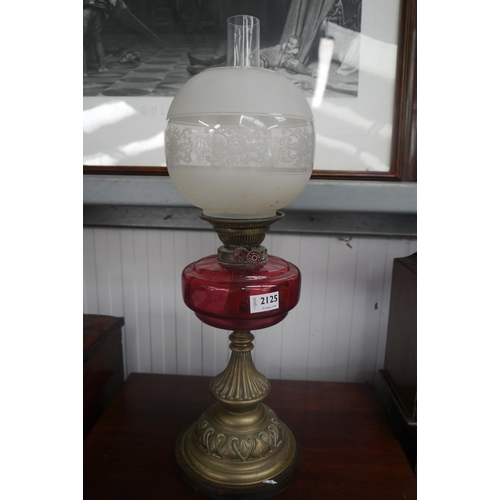 2184 - A Victorian brass and cranberry glass oil lamp with shade