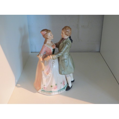 1081 - A musical ornament in the form of a bisque couple in 18th Century attire. 19cm tall. (key missing)