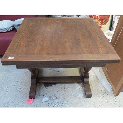 1072 - A 1930s/40s oak draw-leaf dining table on vase-shaped uprights.