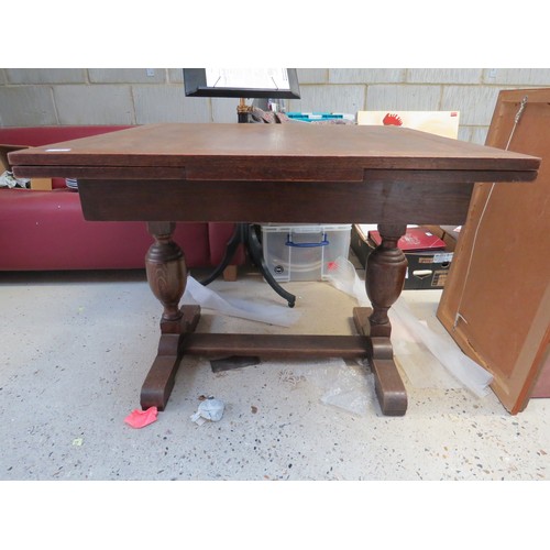 1072 - A 1930s/40s oak draw-leaf dining table on vase-shaped uprights.