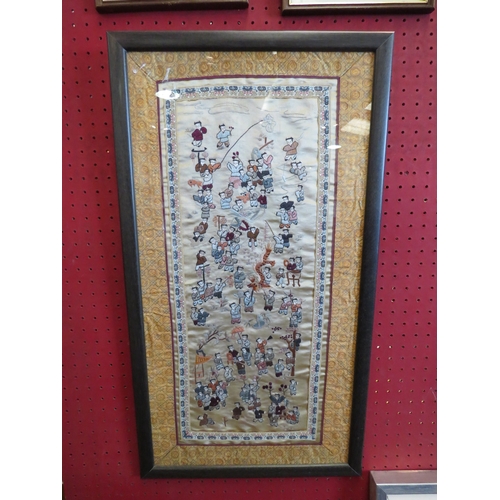 1162 - An Oriental silk panel depicting figures, framed and glazed, 66cm x 36cm total