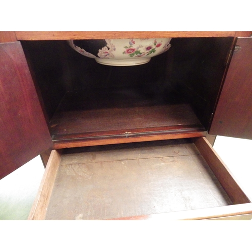 4109 - A George III flame mahogany washstand, the hinged top and wash basin over a two door cupboard and si... 