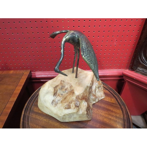 4058 - A brass crane on a yew wood base, 19.5cm tall