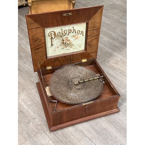 9036 - A tabletop Polyphon, 15.5” disc type, walnut case with incised lyre and foliate design, the lid open... 