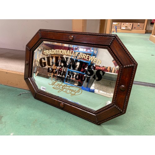 8384 - An oak framed mirror with later painted 'Guinness Extra Stout' to glass