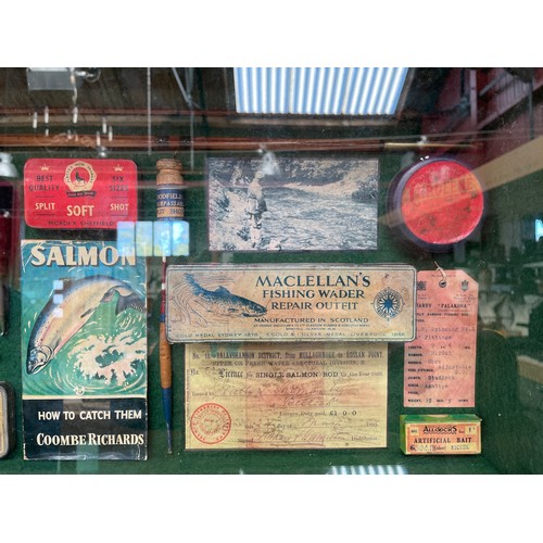 8231 - A glazed display cabinet containing fishing related items; split cane rod, books, lures etc