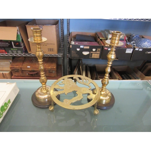 1588 - A pair of turned brass candlesticks (29cm height) and a brass trivet with fretwork lion decoration a... 