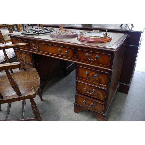 2235 - A reproduction mahogany green leather desk, small tear to leather and some moldings missing