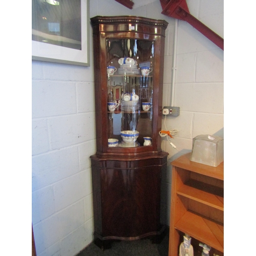 1014 - A mahogany glazed corner cabinet, serpentine front on bracket feet, 182cm tall x 65cm wide