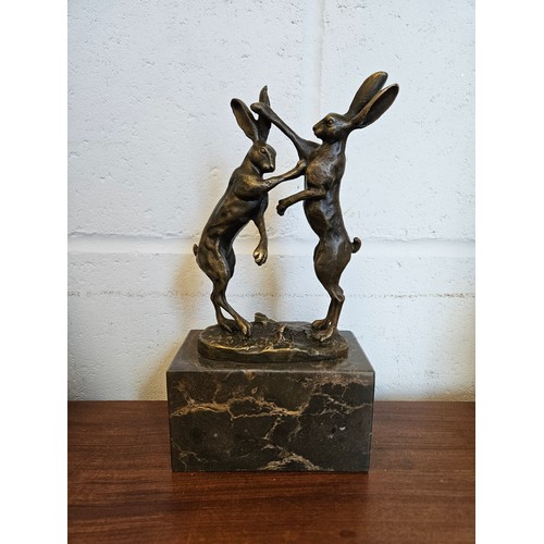 1022 - A pair of bronze boxing hares on marble plinth, 25cm tall