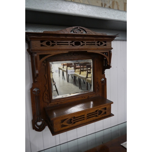 2123 - An Art Nouveau oak wall mirror with pierced details and glove box