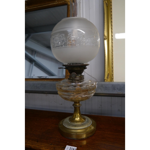 2160 - A Victorian oil lamp, the frosted glass globular shade over a cut glass reservoir to brass base