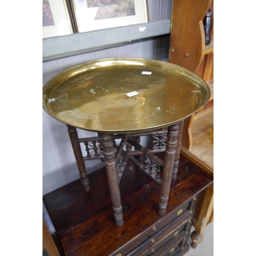 2225 - An Indian brass-top folding table, hardwood base