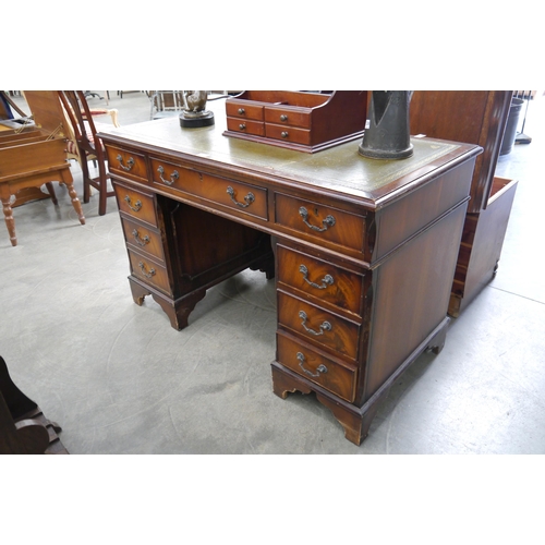 2235 - A reproduction mahogany green leather desk, small tear to leather and some moldings missing