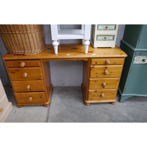 2298 - A modern pine dressing table / desk with eight frieze drawers, turned handles