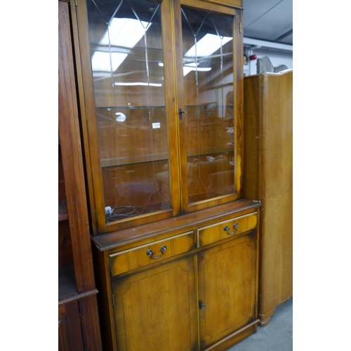 2335 - A yew wood glazed top two-peice cabinet over cupboard