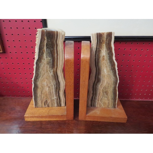 4016 - A pair of polished stone book-ends on wooden bases, 22cm tall