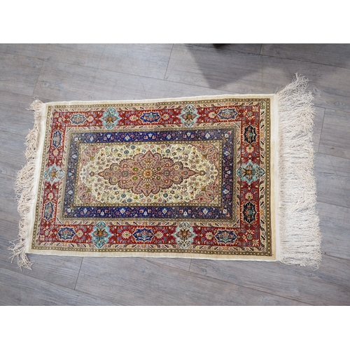 6057 - A 20th Century silk table rug with central floral medallion surrounded by multiple borders, tasselle... 